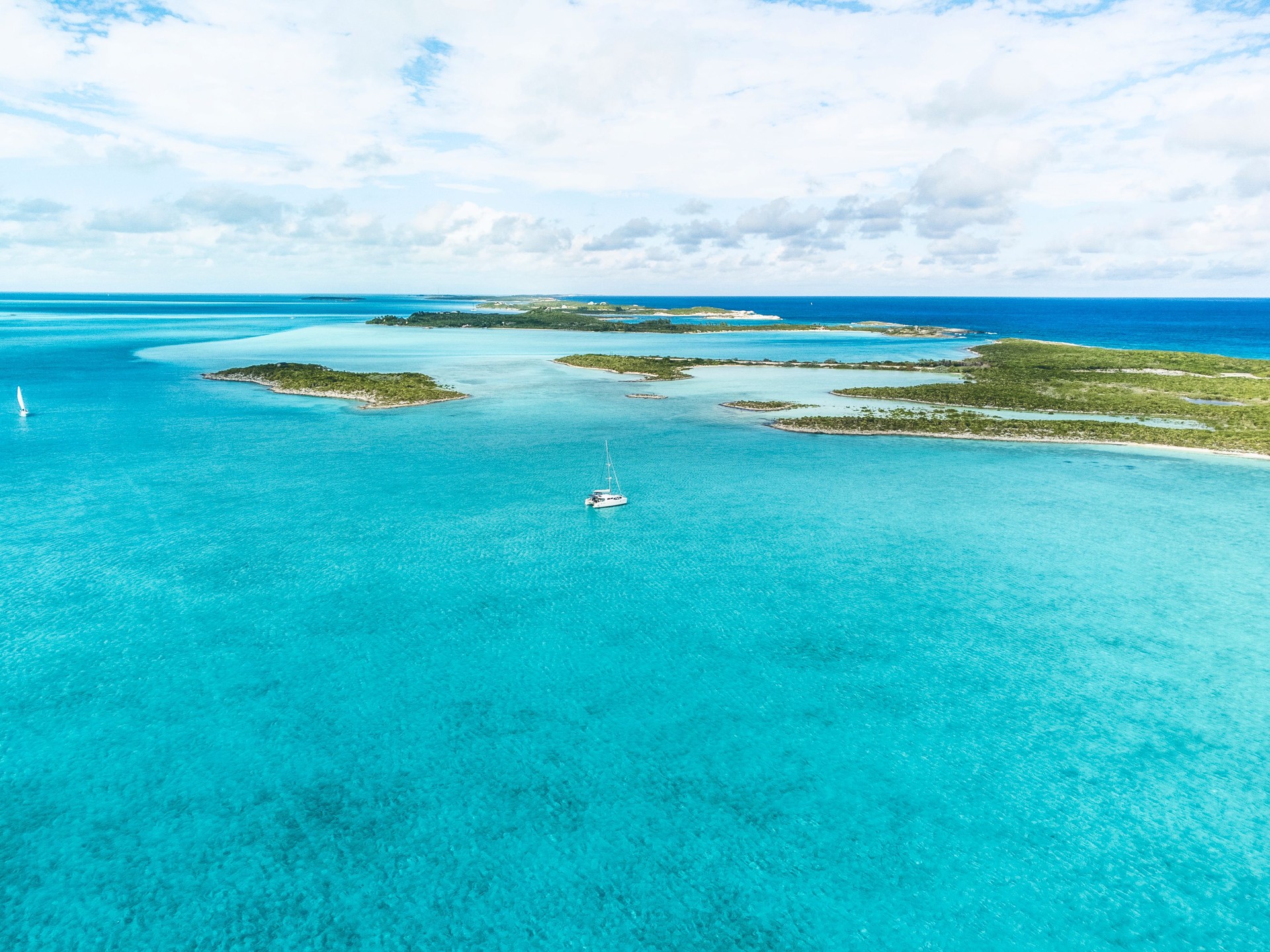 Aerial view of Catamaran anchored in turqoise waters at Musha Cay, Exuma